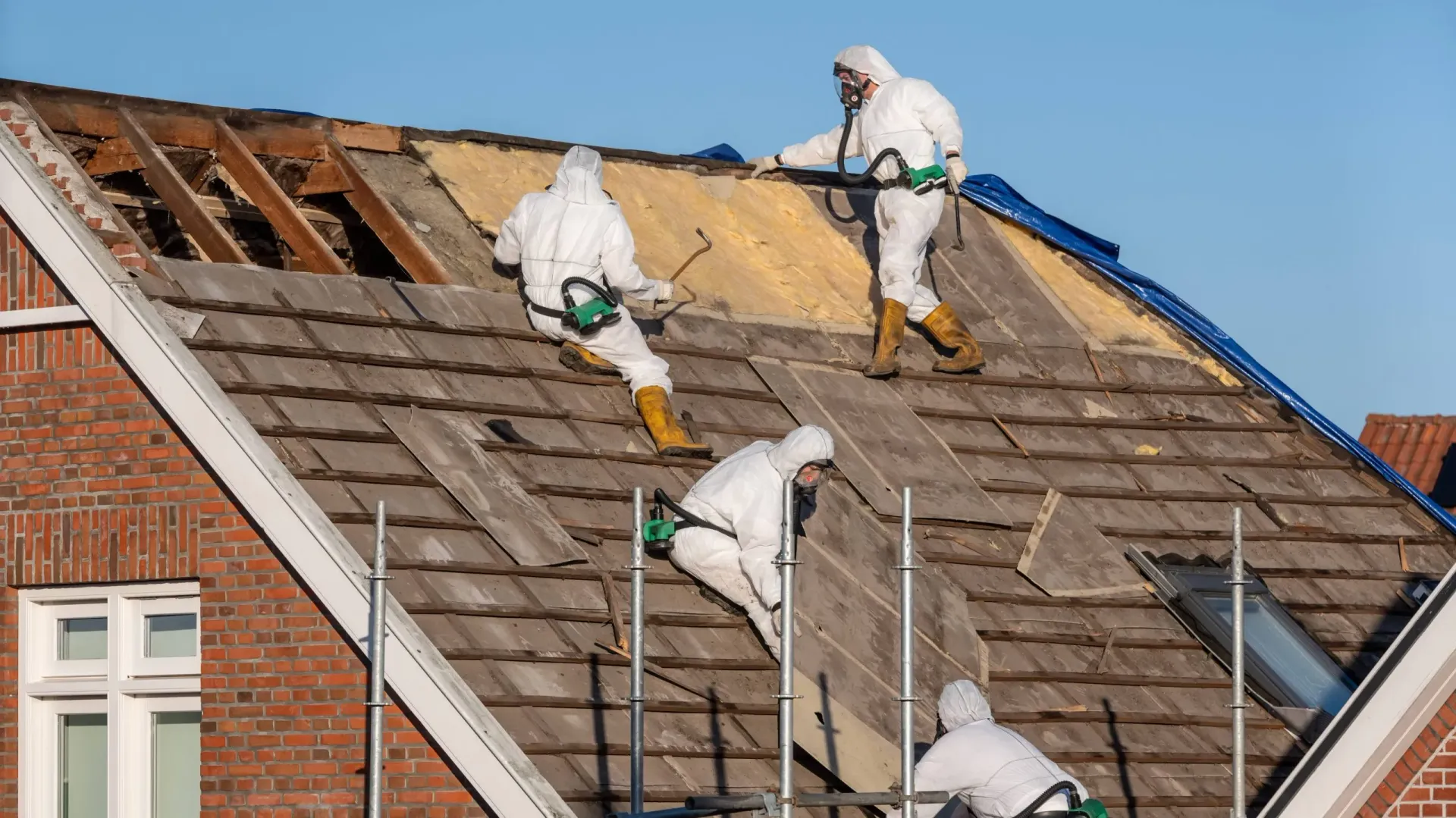 Licensed asbestos removal contractors working on a roof