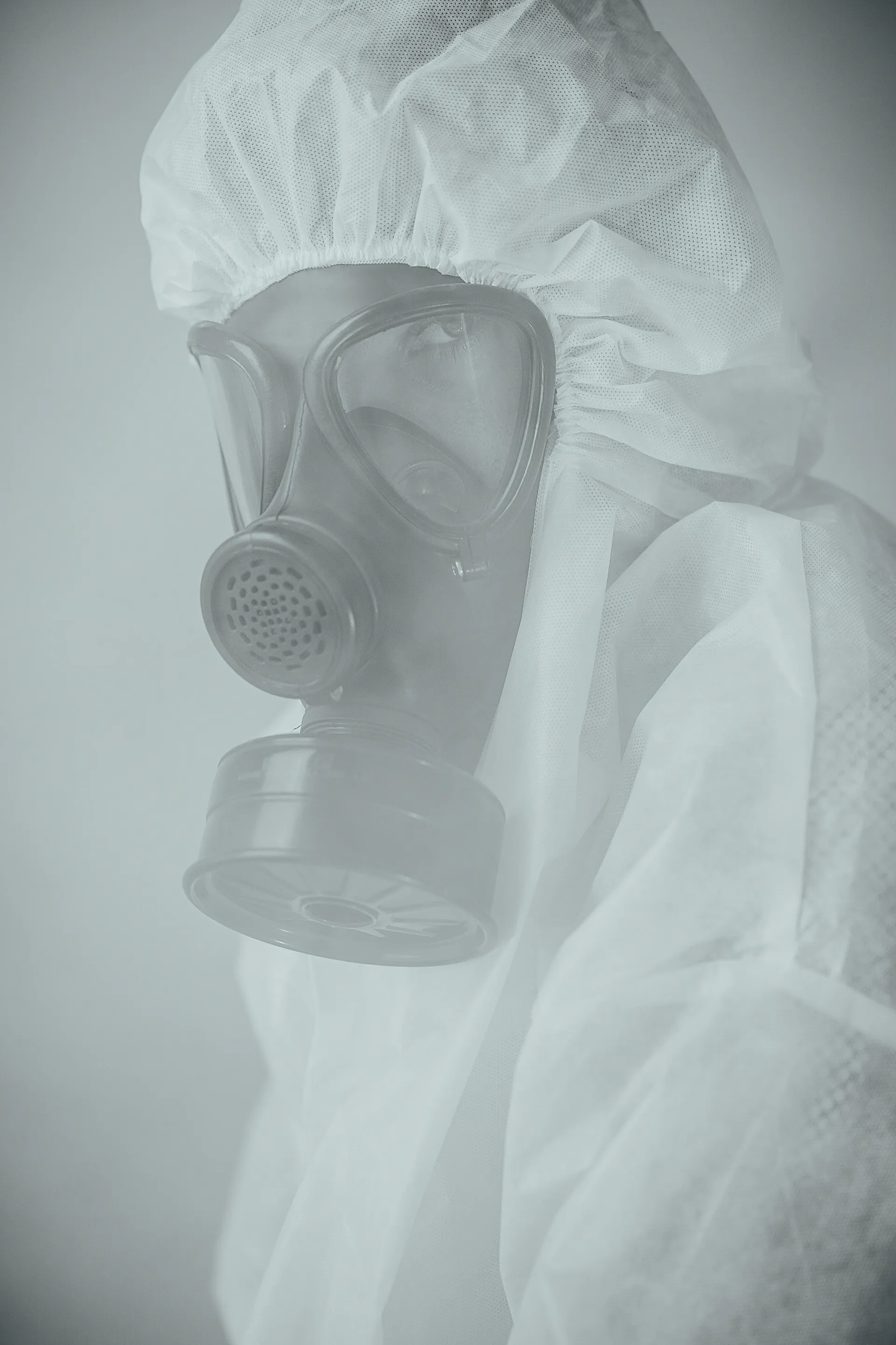 Expert wearing a protective suit and gas mask for asbestos work.